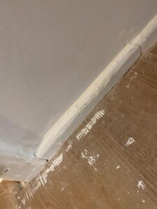 Plaster all over the floor and a very messy skirting board finish